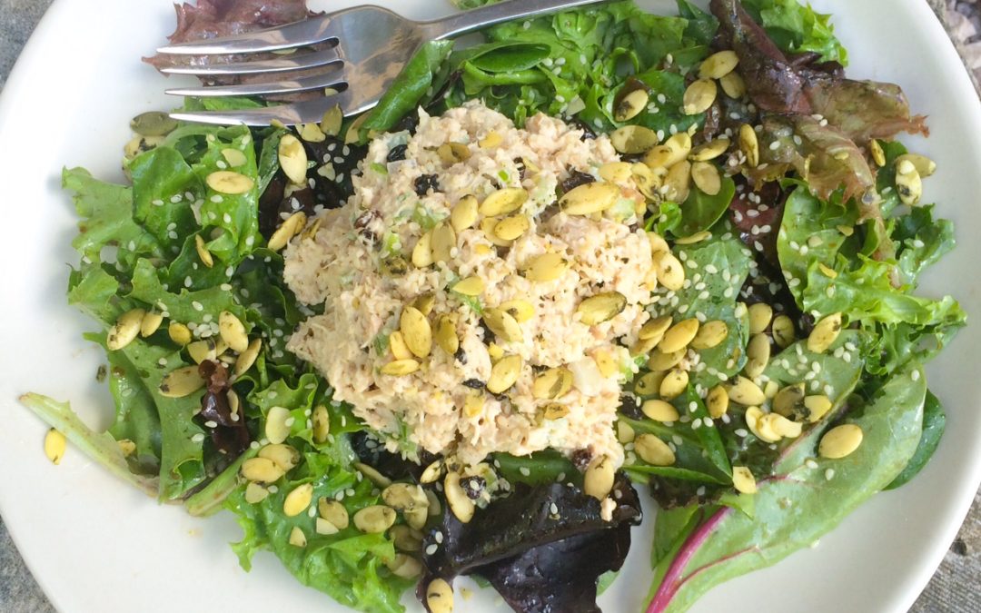Tuna salad with seeds and currants over greens